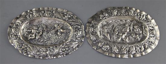 A pair of Augsburg small silver oval plaques, embossed with cherubs, masks and foliage, with Austrian import marks,